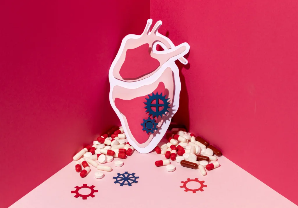 Stylised heart illustration surrounded by pills and gear icons on a pink background.