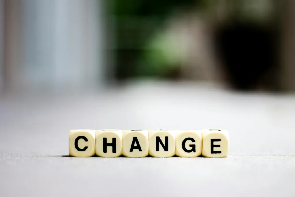 Letter tiles arranged to spell “CHANGE” on a neutral background.