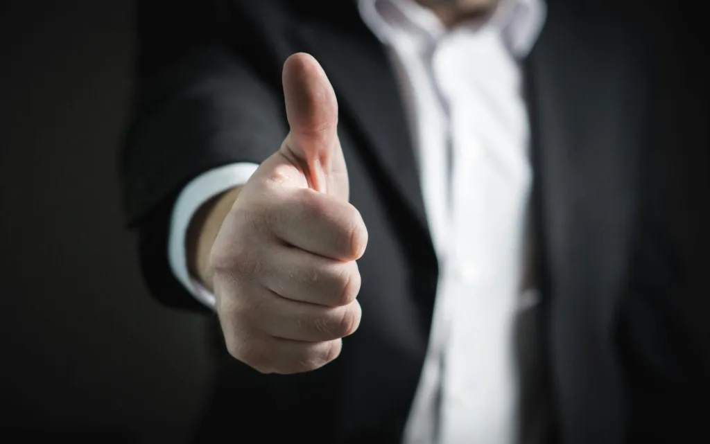 Person in a suit giving a thumbs up gesture