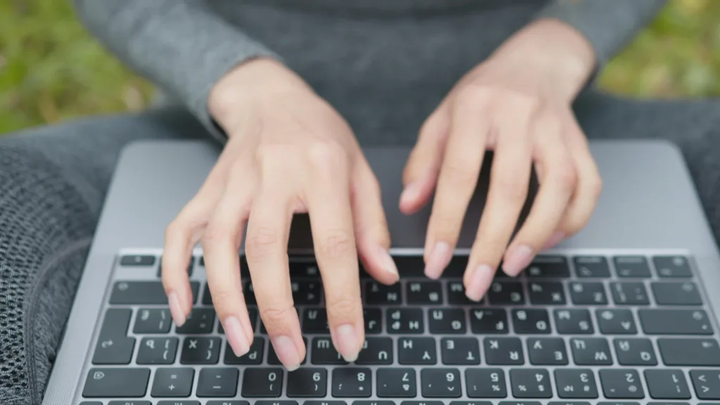 Close-up of hands on a computer keyboard.