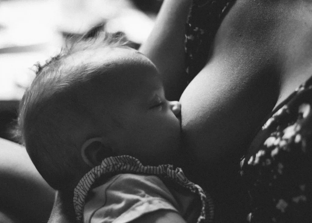 Black and white close-up of a baby breastfeeding