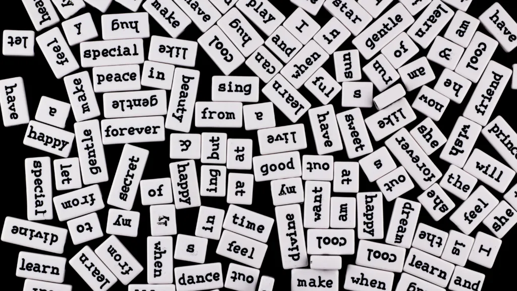 Black background with many small scattered tiles with random words on them.