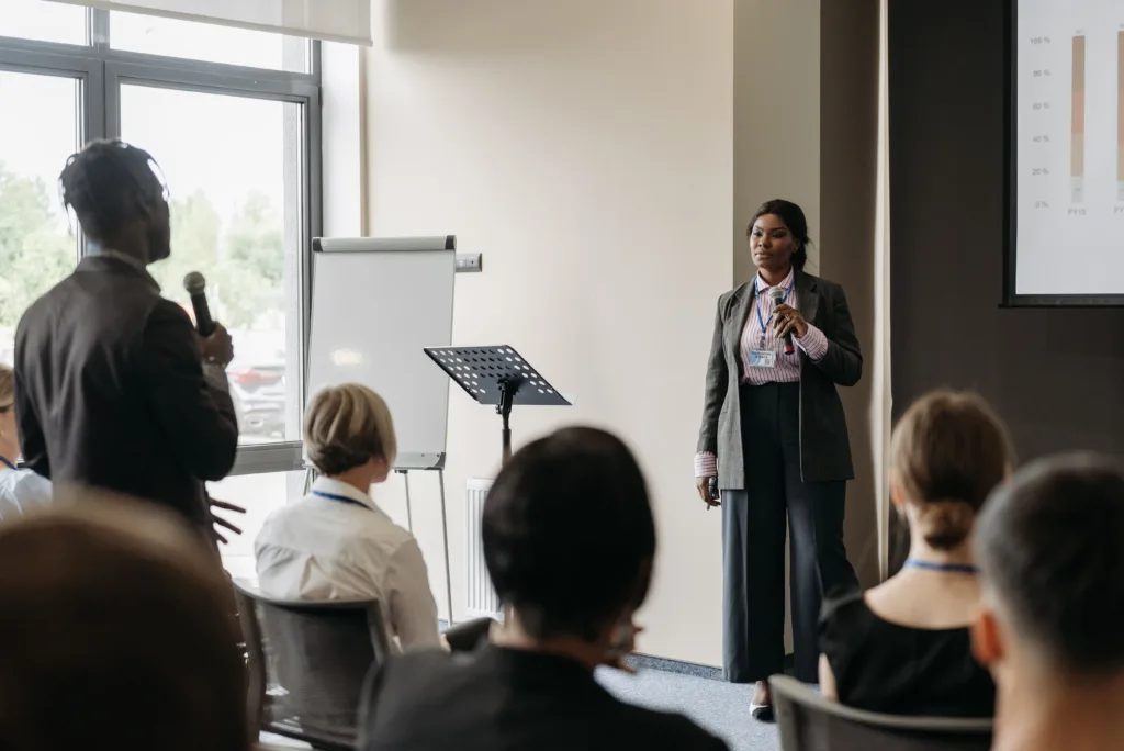 Professional business conference presentation with diverse participants engaging in communication
