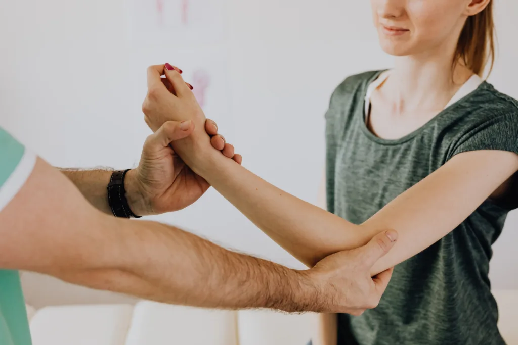 Image of a physiotherapy session focusing on arm movement and manual adjustment