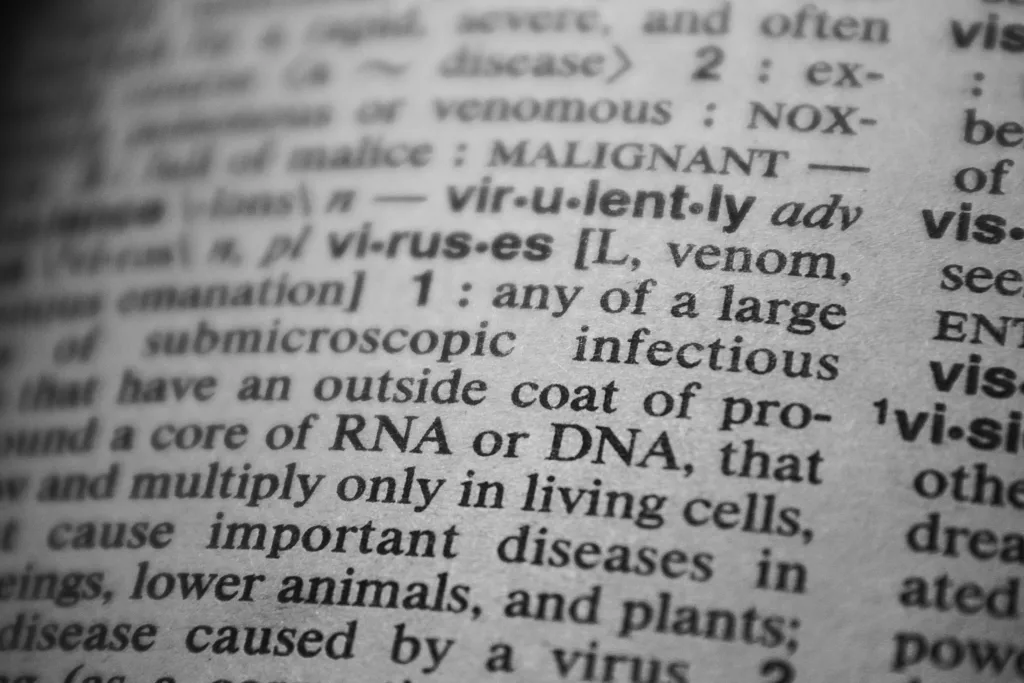 Black and white close-up of a dictionary page focusing on the definition of 'virus'