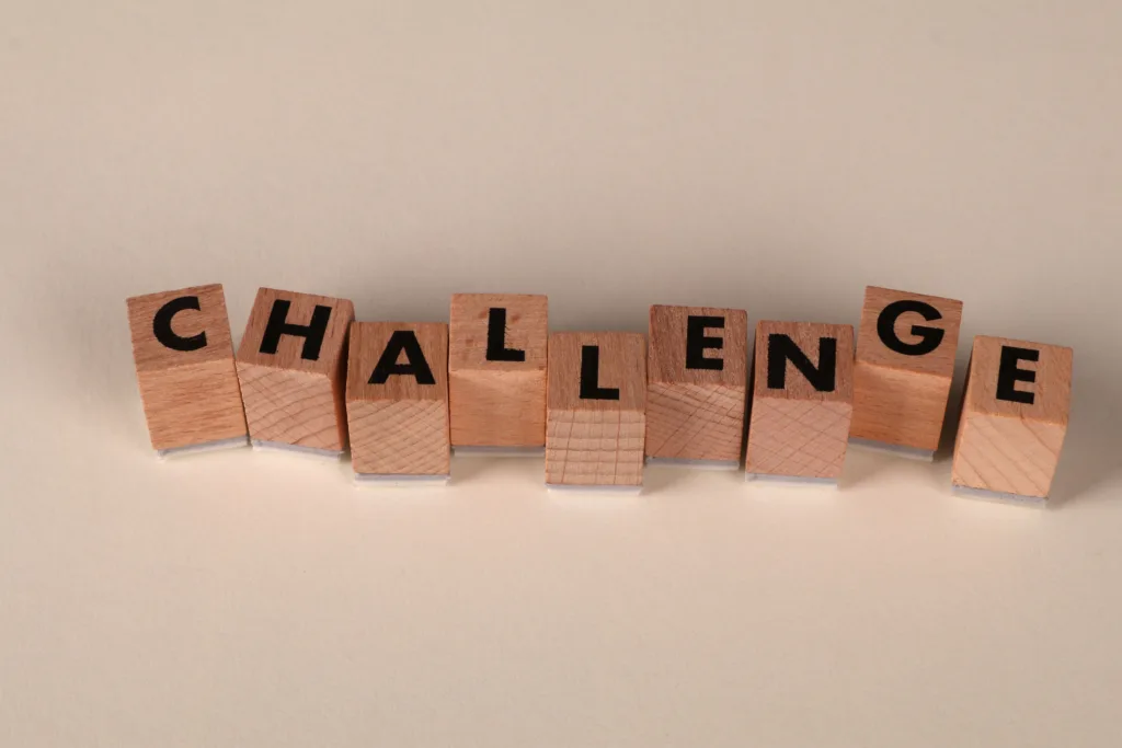 Wooden blocks arranged to spell 'Challenge' against a neutral backdrop.